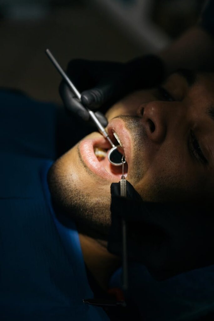 Detailed close-up of a dental examination with a mouth mirror and probe at a clinic.
