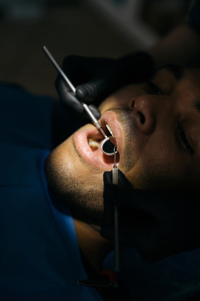 Detailed close-up of a dental examination with a mouth mirror and probe at a clinic.