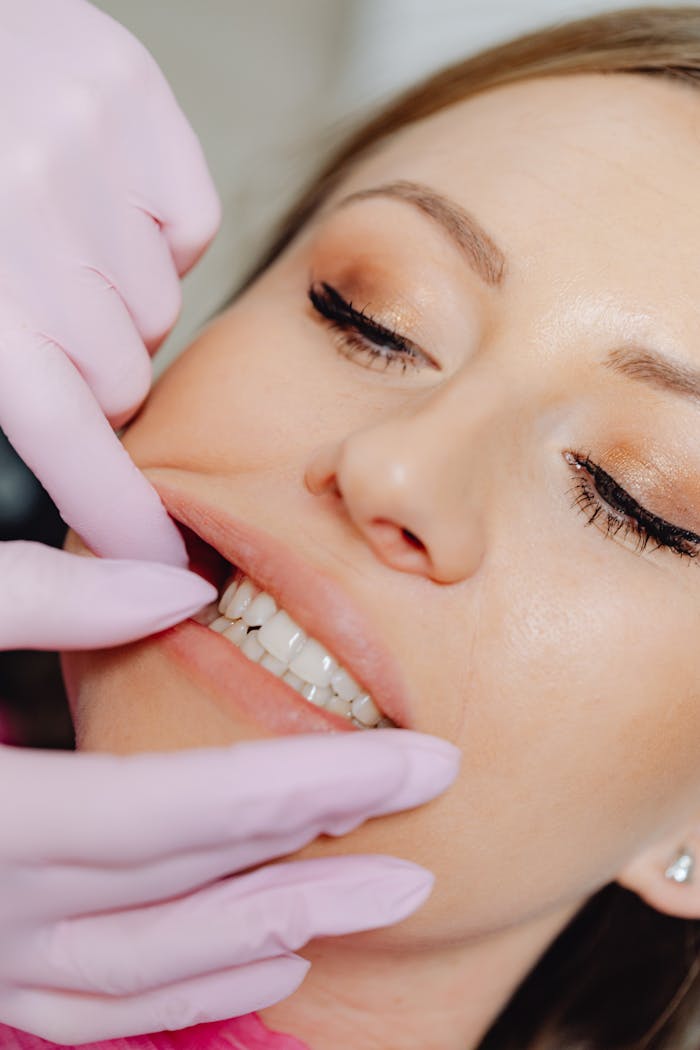 Detailed close-up of a dental examination showing a woman's teeth with latex gloves.